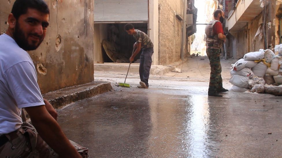 Tracey Shelton Life and death in Aleppo, From left to right: Issa Aiash, 30, father of three, his young brother Ahmed, 17, and Sheihk Mamoud, 42, father of a newborn son, laugh and joke as they clean their post Saturday.(Tracey Shelton - GlobalPost)